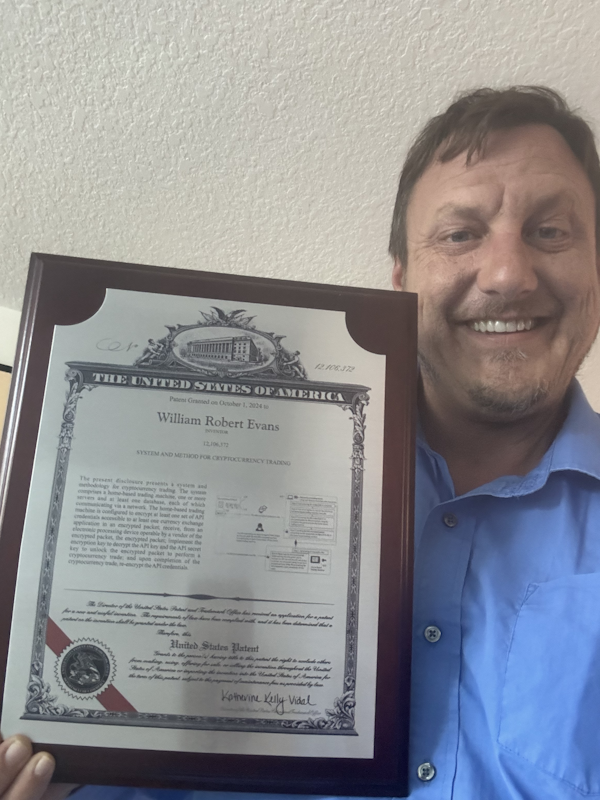 Robert holding the granted patent document